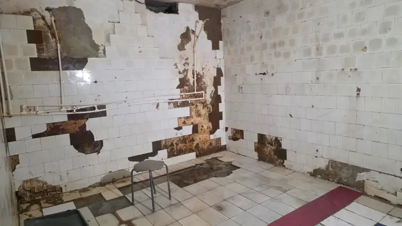 Жильцы старого общежития в Актобе вынуждены платить за душ и сталкиваются с разрушением дома, что усугубляет условия жизни и создает коммунальные проблемы. Актобе