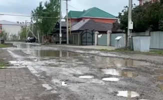Жители элитного района в центре Актобе жалуются на отсутствие асфальтированных дорог, вынуждены передвигаться по грязи.